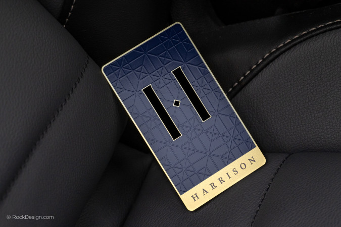 Luxury navy blue and matte gold metal business card with geometric etching and cut-through design.